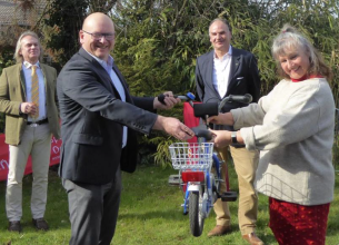 Landrat Frank Matiaske übergibt symbolisch ein Fahrrad an Susanne Hürten von der Brückenschule